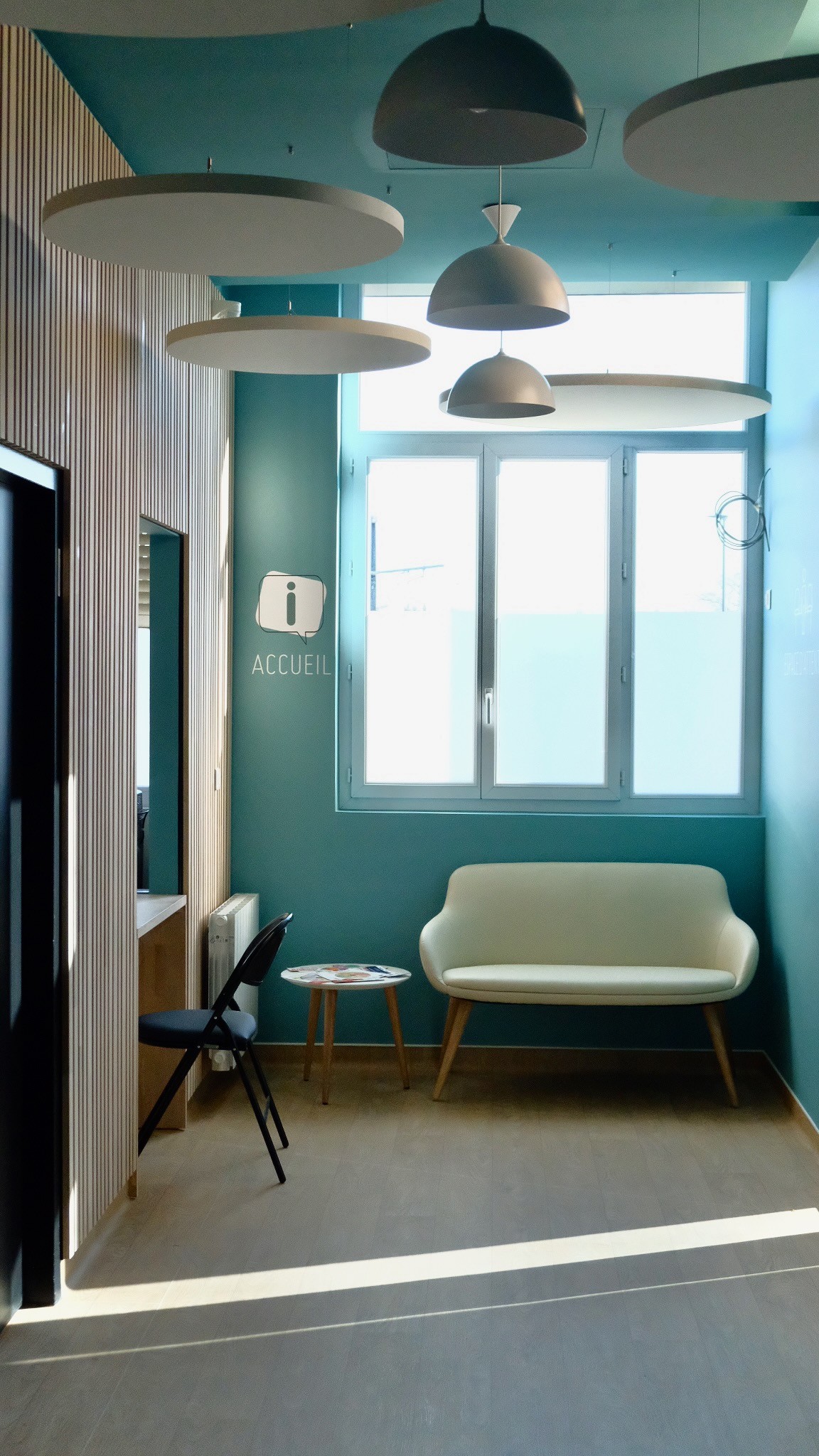 Hall d'accueil présentant une banquette et une banque d'accueil administratif